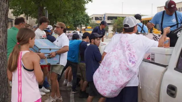 टेकस्सको बाढीग्रस्त क्षेत्रमा सामान जम्मा गरिराखेका मानिसहरू