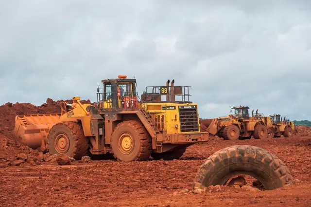 Des bulldozers déplacent de la bauxite brute dans une mine