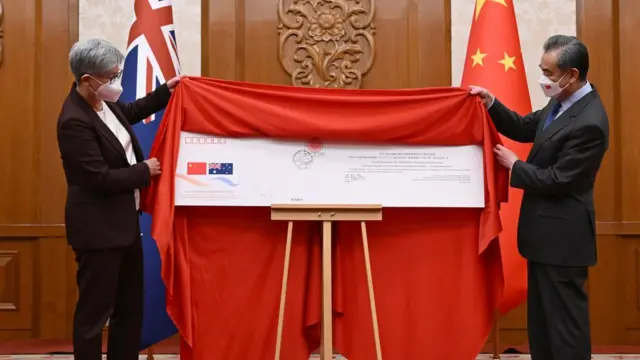 黄英贤（左）与王毅（右）在北京钓鱼台国宾馆为中澳建交50周年纪念邮政首日封揭幕（21/12/2022）