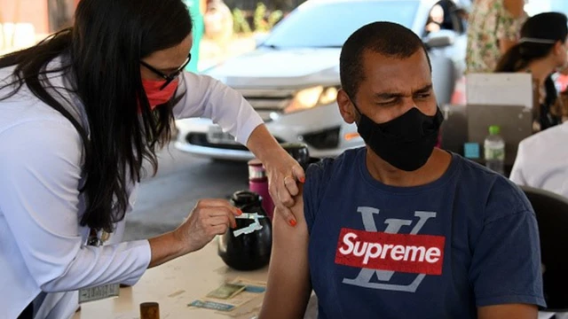 Homem recebe vacina no braço