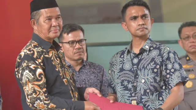 Kanit IV Subdit Resmob Ditreskrimum Polda Metro Jaya, AKP Charles Bagaisar (kedua kanan) memberikan berkas kepada Hamidi (kiri) yang merupakan bapak dari Alm Farhan di Rumah Sakit Polri, Jakarta Timur, Jumat (7/11/2025).