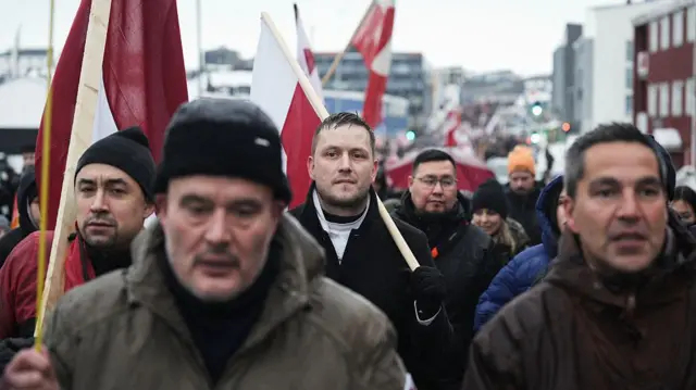 Премьер-министр Гренландии Йенс-Фредерик Нильсен (в центре) принимает участие в митинге, на котором собралось почти треть населения города, чтобы протестовать против планов президента США захватить Гренландию, 17 января 2026 года в Нууке, Гренландия.