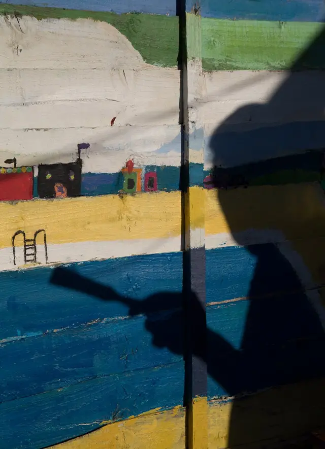 ظل رجل يرسم على جدار