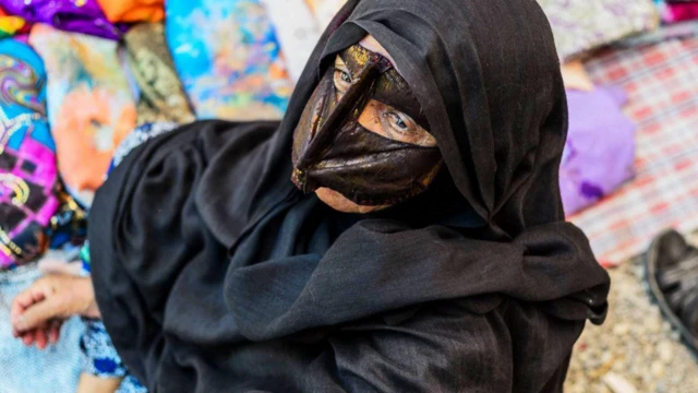 मास्क पहनी हुइ एक ईरानी बंदारी महिला