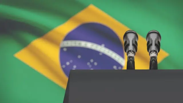 Púlpito com microfone e bandeira do Brasil ao fundo