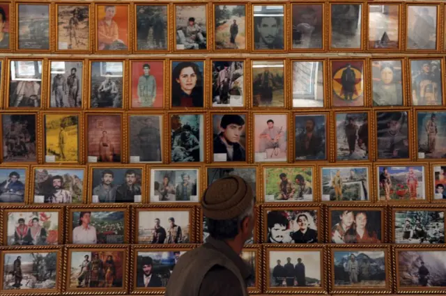 2009'da kampta çekilen fotoğrafta, çatışmalarda ölen PKK üyelerinin resimleri yer alıyor. Bir adam, bu kişilerin duvardaki resimlerine bakıyor.