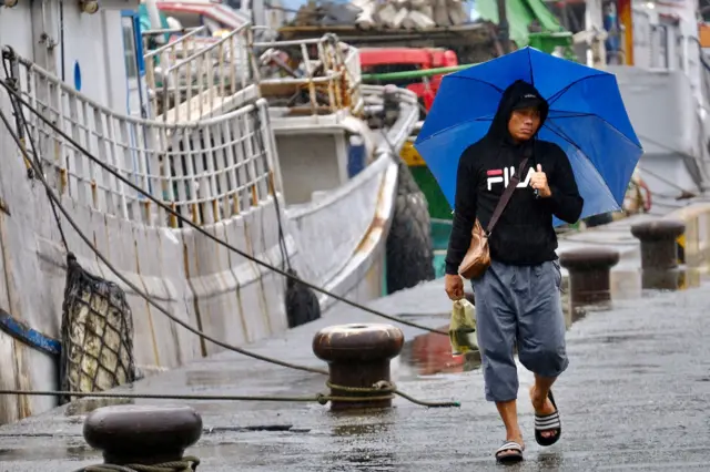 圖片攝於宜蘭蘇澳，一名在漁業工作的菲律賓移工走過碼頭
