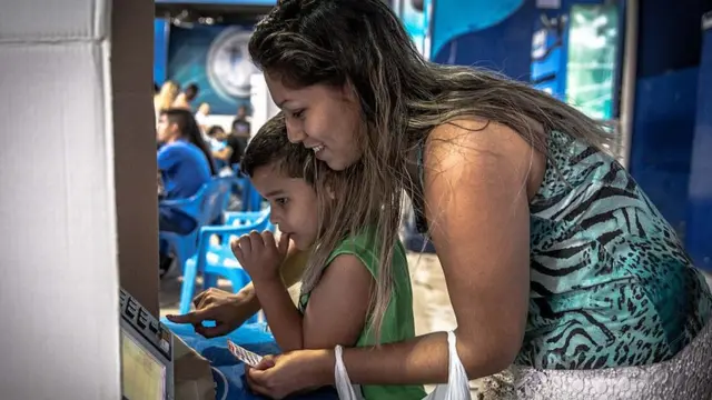 Eleitora vota nas eleições presidenciaisjogo on line cef2014 acompanhadajogo on line cefuma criança