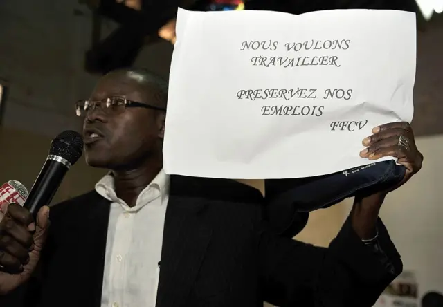 Wan mutum ɗauke da saƙon da aka rubuta a harshen Faransanci cewa "Muna muradin ci gaba da aiki. Ku barmu da aikin mu FFCV.