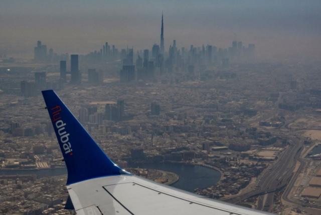 مشهد جوي لأفق دبي يظهر فيه جناح طائرة، وبرج خليفة  كما يُرى من طائرة