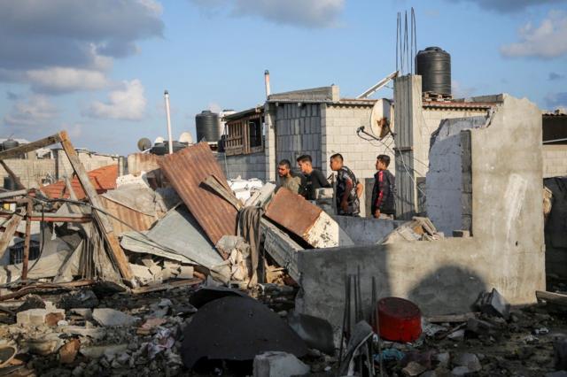 Palestinos inspeccionan casas dañadas en un ataque israelí en Rafah.