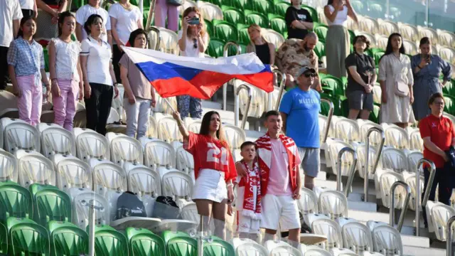 Uma torcedora russa agita uma bandeira durante o amistoso feminino entre Rússia e Coreia do Norte, em Moscou