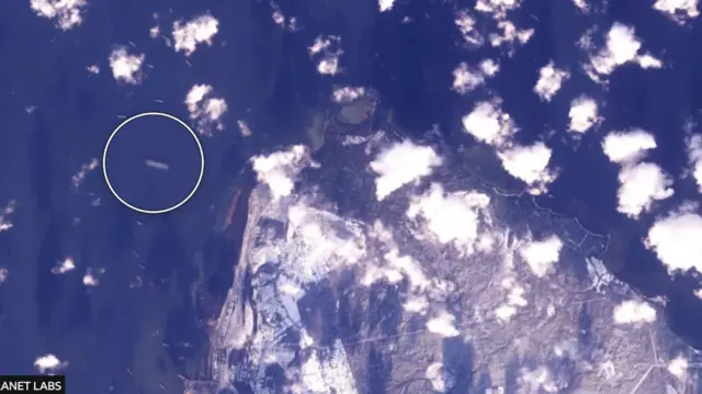 Супутникове зображення узбережжя, оточеного суднами