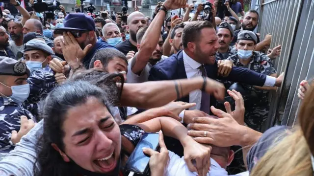 Activists and relatives of victims of the Beirut port explosion scuffle among themselves as Lebanese security members try to interfere during a demonstration on September 29, 2021 outside the capital's Justice Palace