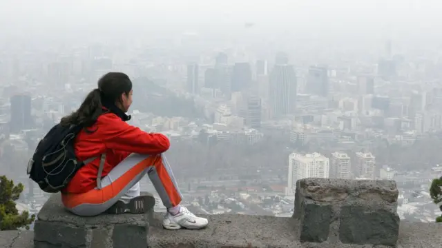 Una chica observa la ciudad desde el cerro San Cristóbal.
