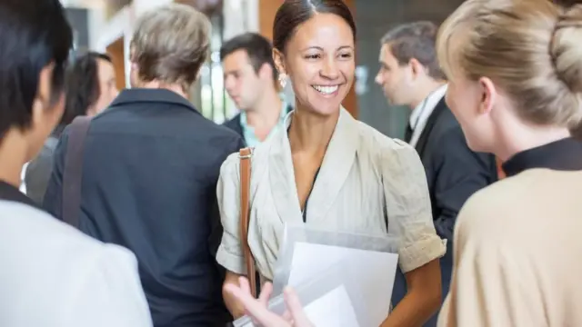 Una joven sonriendo entre un grupo de gente