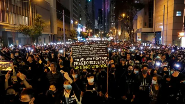 A protester holds a placard as he attends a Human Rights Day march, organised by the Civil Human Right Front