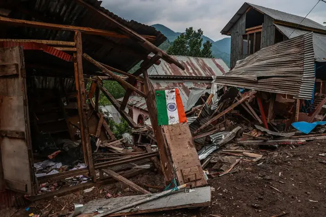 Bendera India di depan bangunan yang rusak di Pakistan, 9 Mei 2025.