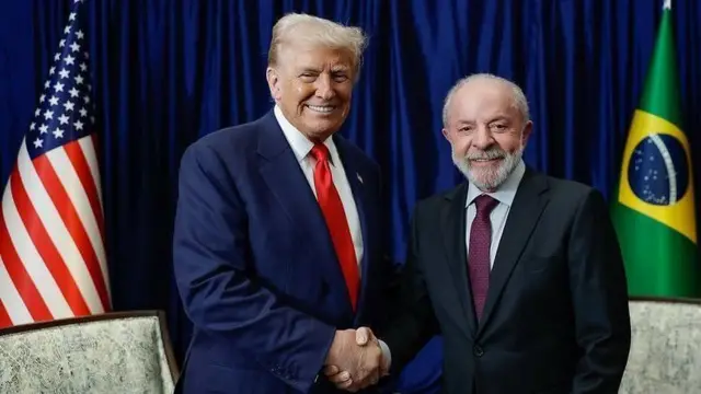 Trump e Lula sorrindo para foto enquanto apertam as mãos