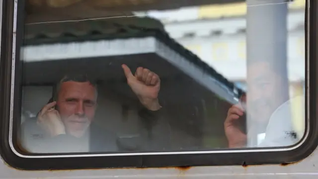 Мобилизованные машут родным из окна поезда