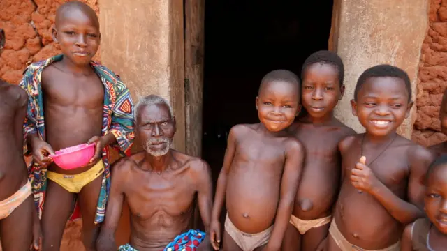 Un homme et des enfants sur le pas de leur porte dans un village de la province du Zou, au Bénin.