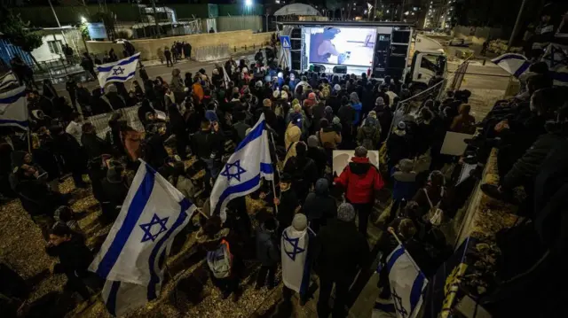 Исроил байроқлари ва баннерларини кўтариб олган ўнг қанот исроилликлар 2024 йил 5 февралида БМТнинг Фаластин Қочқинлари учун кўмак агентлиги идораси қаршисида уюштирган норозилик намойиши