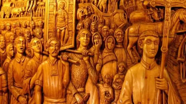  Горельєф "Великий шлях греків у Приазовʼє", виконаний на деревині, на ньому зображені жінки і чоловіки, які несуть хрест, ікони та речі