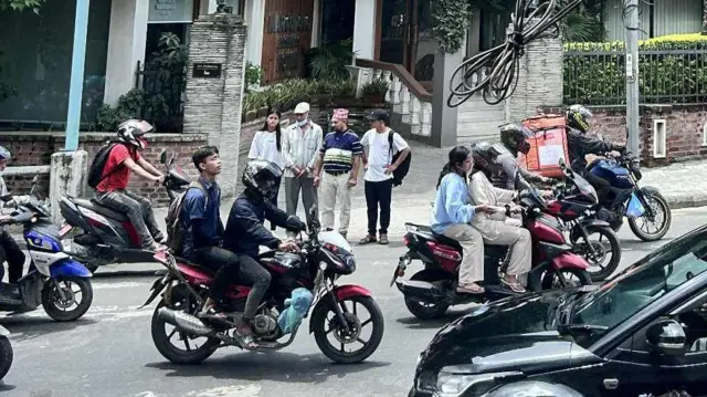 पैदलयात्रीहरू जीब्राक्रसबाट बाटो काट्न पालो कुर्दै 