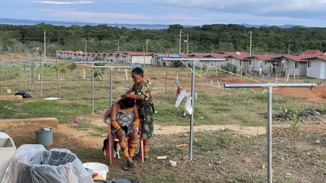 Uma mulher corta o cabelo de sua filha na favela de Isberyala.