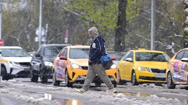 Чоловік переходить дорогу під снігом
