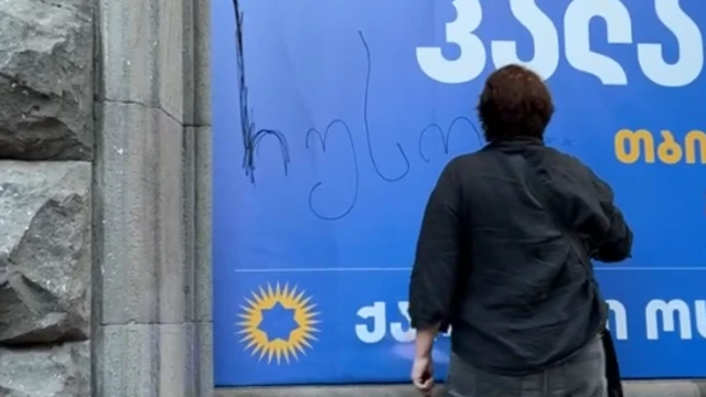 Элене Хоштария оставляет надпись на баннере Каладзе