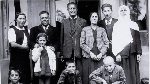 Photo en noir et blanc d'une famille de réfugiés juifs avec leurs hôtes albanais