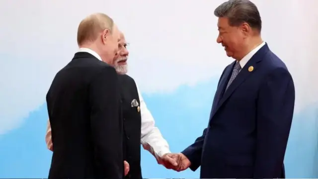 رئیسجمهور روسیه، ولادیمیر پوتین، نخستوزیر هند، نارندرا مودی، و رئیسجمهور چین، شی جینپینگ، در تاریخ ۱ سپتامبر ۲۰۲۵، در جریان نشستی از سازمان همکاری شانگهای (SCO) در تیانجین چین، با یکدیگر گفتوگو میکنند.