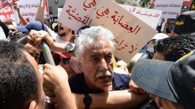 زعيم حزب العمال حمة الهمّامي (وسط) خلال تظاهرة في العاصمة تونس عام 2022