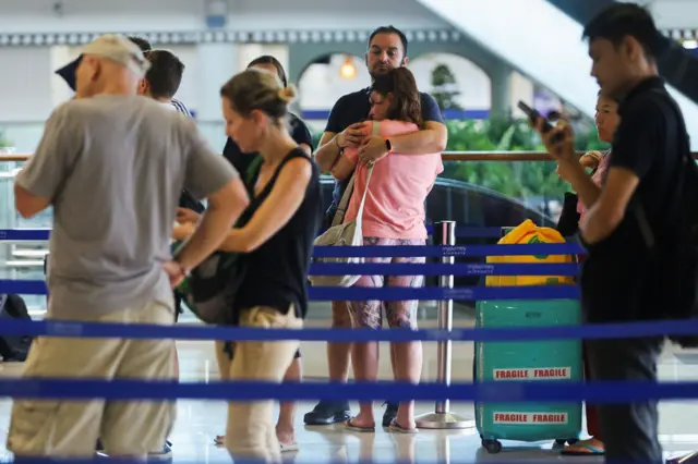 Los pasajeros varados hacen cola en el servicio de atención al cliente de Qatar Airways en el Aeropuerto Internacional I Gusti Ngurah Rai en Indonesia después de que se cancelaran los vuelos a Doha, Dubái y Abu Dabi tras los ataques contra Irán lanzados por Estados Unidos e Israel.