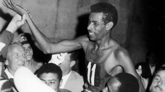 አትሌት አበበ ቢቂላ ከድል በኋላ ታዳሚዎች በትከሻቸው ተሸክመውት