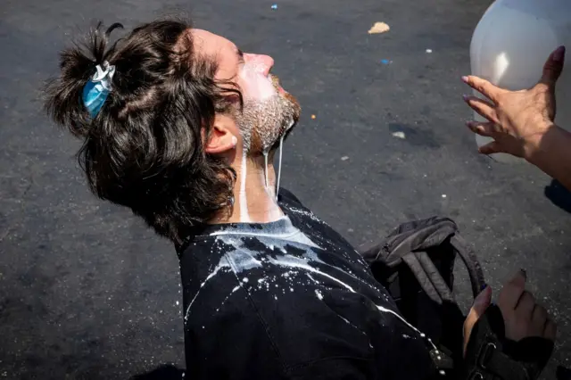 Muškarac oblivljen mlekom zbog suzavca