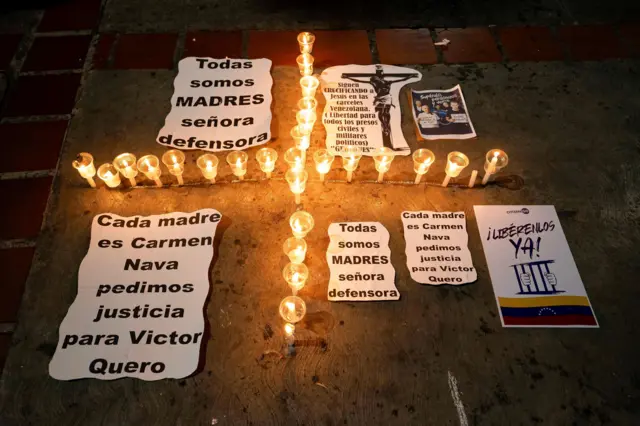 Mensajes de apoyo durante una vigilia organizada por familiares de presos en memoria del fallecido Víctor Hugo Quero y en solidaridad con su madre y con críticas a la Defensora del Pueblo. En los carteles se puede leer "Cada madre es Carmen Nava, pedimos justicia para Víctor Quero", "Todas somos madres, señora defensora". Los cartles rodean a una cruz hecha con pequeñas velas. En otro cartel se lee "Libérenlos ya, con la bandera de Venezuela".