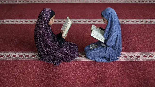 Des jeunes Palestiniennes étudient le saint Coran dans une mosquée pendant le mois de jeûne musulman du Ramadan, dans la ville de Gaza, le 6 avril 2022
