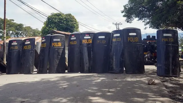 Polisi meletakkan tameng-tameng mereka usai bertugas saat kerusuhan massa di Wamena, Papua, Jumat (24/2/2023).