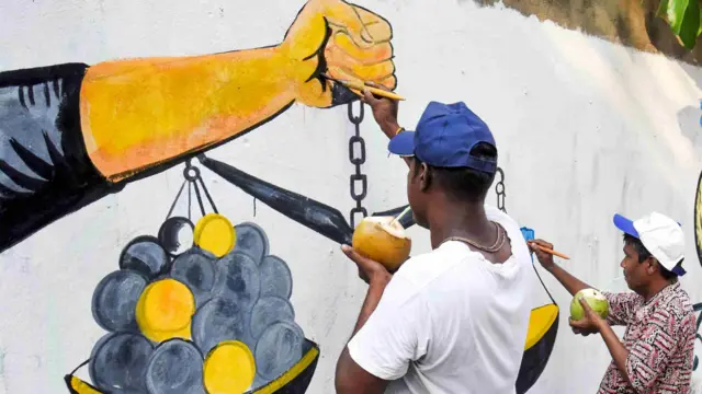 নির্বাচনী প্রচারের অংশ হিসেবে রাসবিহারী কেন্দ্রে শিল্পীরা দেয়ালে আকঁছেন — ফাইল ছবি। 