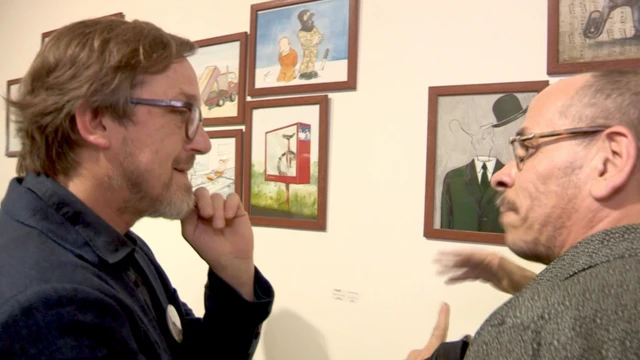 اثنان من الرسامين الأجانب أمام عدد من الرسومات