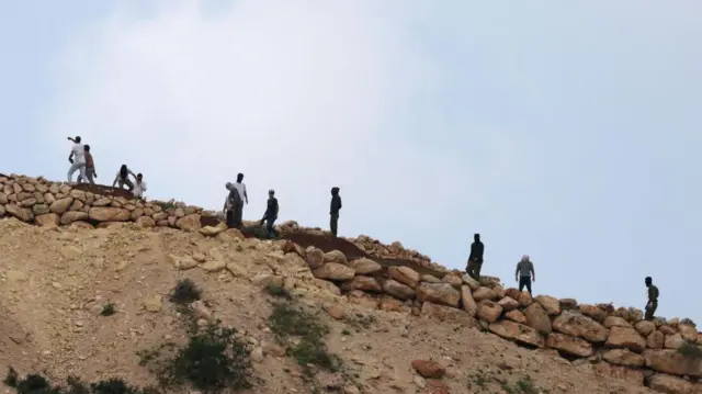 مستوطنون إسرائيليون يتجمعون على تل يطل على قرية المغير قرب رام الله في الضفة الغربية