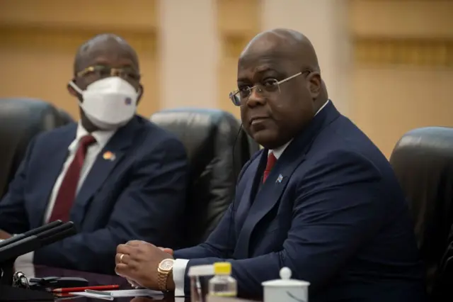 Le président Félix Antoine Tshisekedi en costume bleu marine avec cravate rouge (à droite)