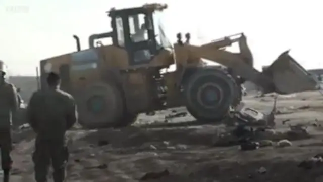 Un bulldozer sur le terrain où sont tombés les débris de l'avion