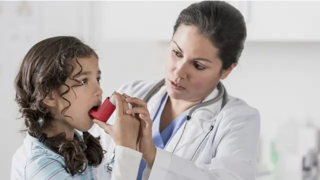 Menina aprendendo a usar um inalador