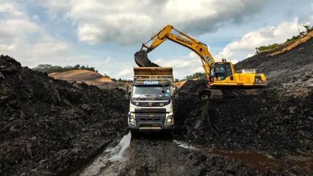 Kendaraan pertambangan memuat material batubara ke dalam truk di tambang batubara terbuka di Kalimantan Selatan, pada 8 Desember 2024.