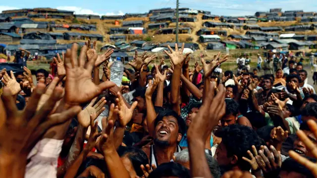 在孟加拉一个难民营的罗兴亚人等待空投的救援物质，