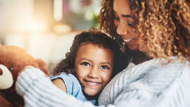 Una niña abrazada con su madre.