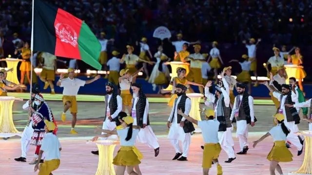 مسئولان ورزشی طالبان زیر پرچم سه رنگ دولت پیشین و پرچم‌داری زن ورزشکار در بازی‌های آسیایی چین